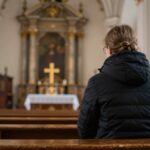 Osoba modląca się przed spowiedzią w kościele w Lublinie